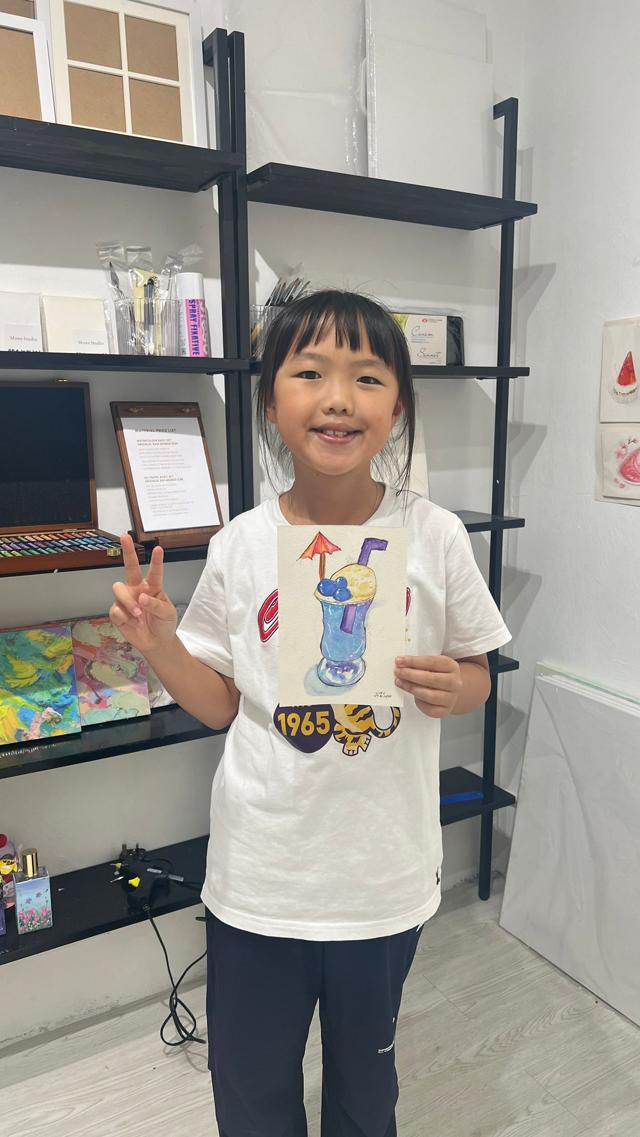 ArtVenture student proudly displaying finished artwork in studio